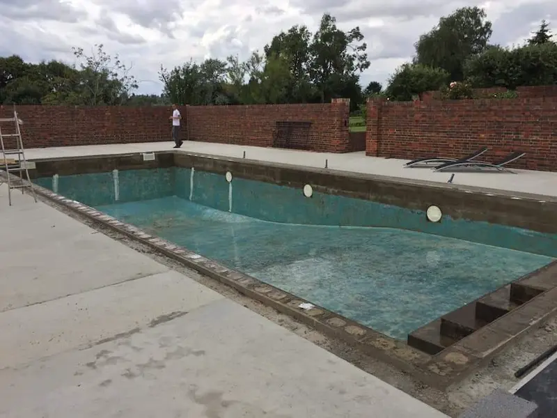 Pool shell diamond grinded shell repaired where required and application of a vinyl ester primer coat